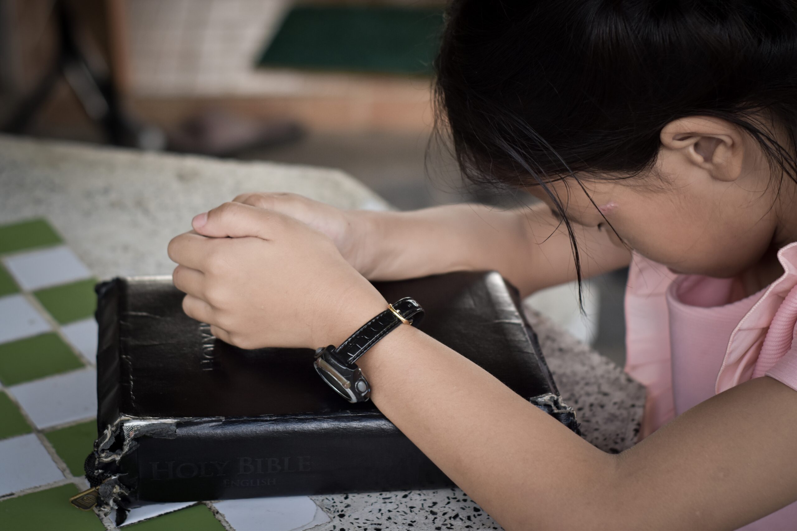 Child girl hands praying with a holy bible. Concept of religion christian.