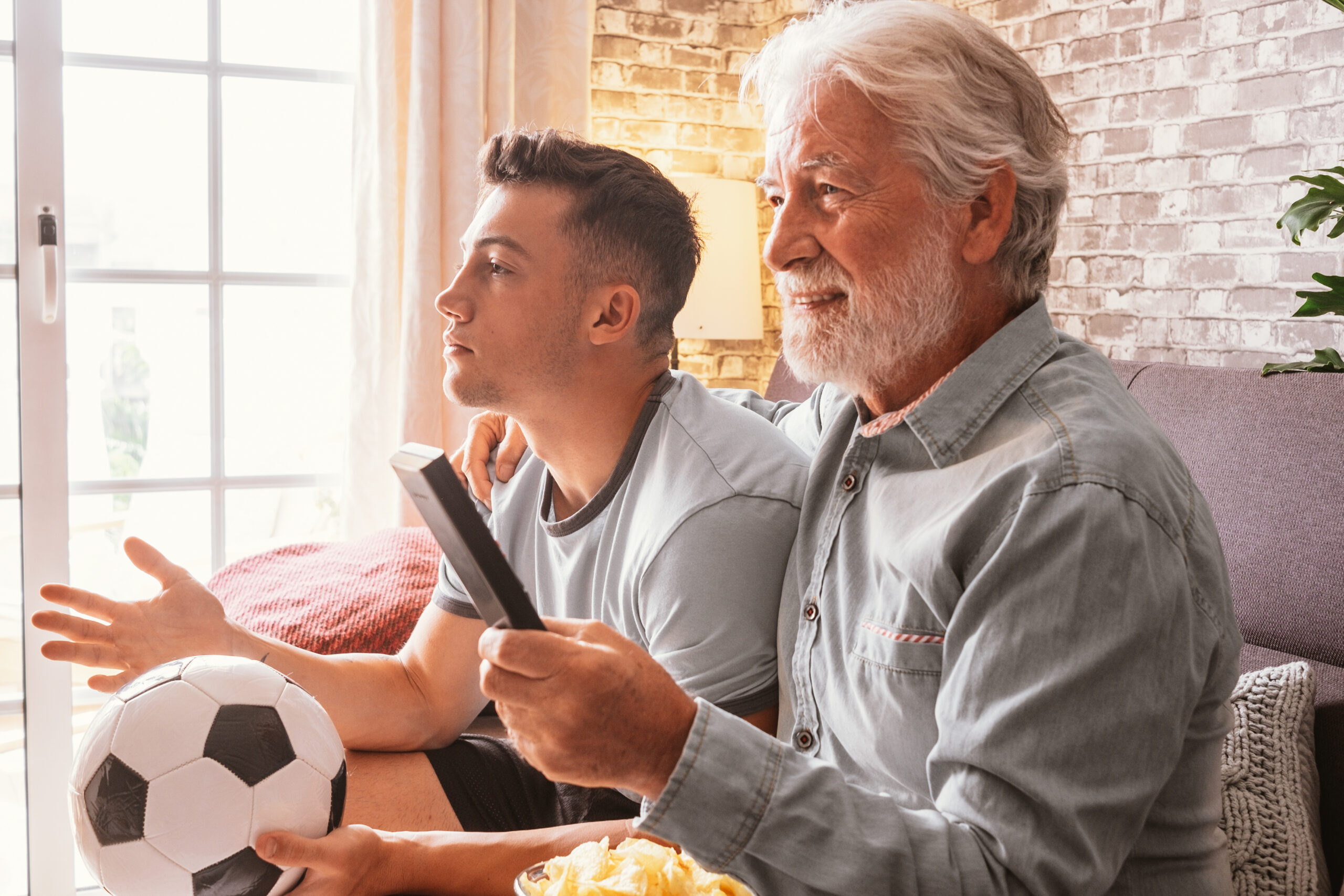 Caucasian couple of young boy and senior grandfather soccer fans