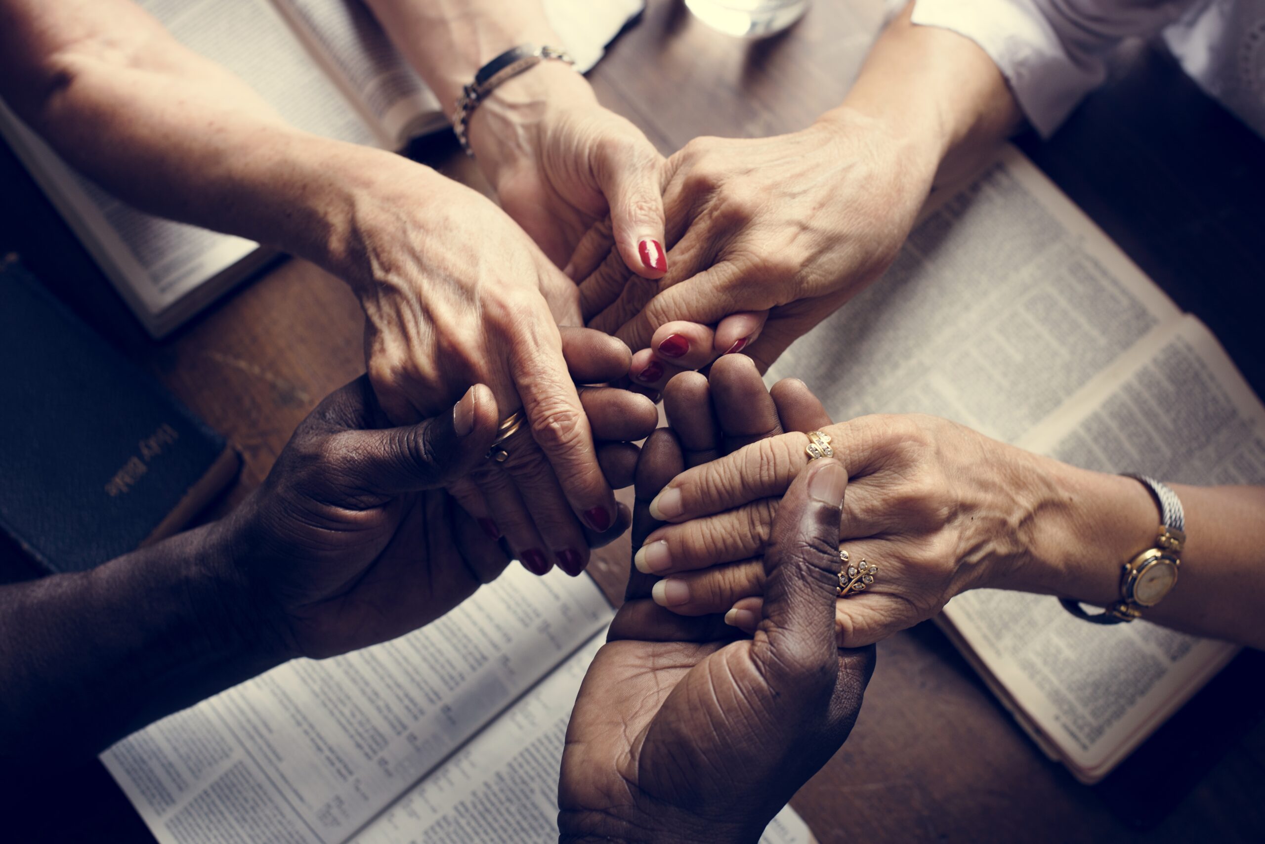 Group of people holding hands praying worship believe
