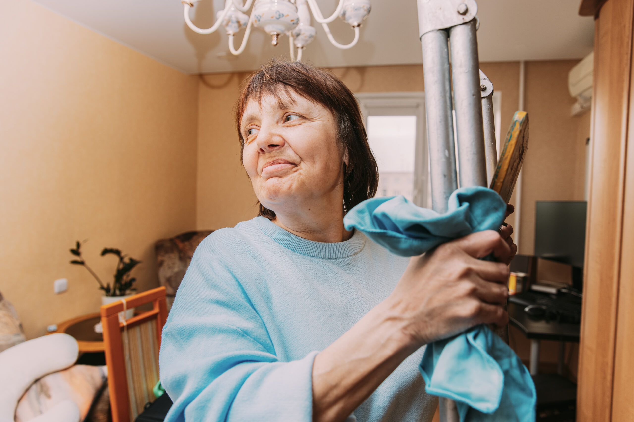 Happy Shy Mature Woman Cleaning Apartment. Concept Of Household And People In Retirement. Elderly Woman Cleaning Apartment. Active Seniors Concept. Caucasian Woman Middle Age. Housewife